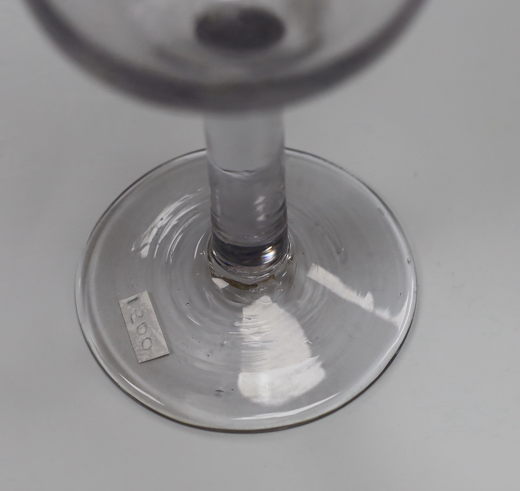 An English lead crystal goblet, c1740-50, ogee bowl with tool marks, engraved fruiting vines and a bird, with a plain stem, conical foot and rough pontil, 19.4cm